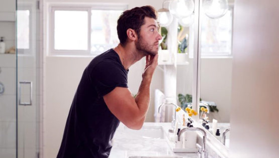 Man Washing face with Tri Wash in Bathroom