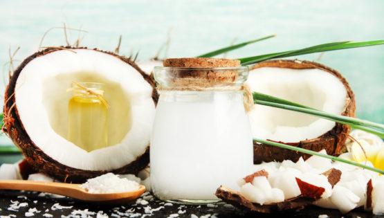 Coconuts with jar of Coconut Milk and Spoon full of Coconut Oil