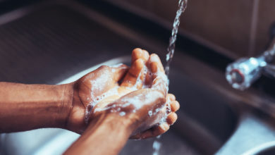 Washing soapy hands under sink
