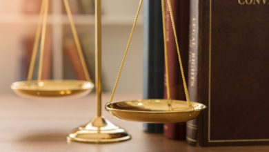 Gold balance scales with old books behind