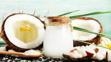 Coconuts with jar of Coconut Milk and Spoon full of Coconut Oil