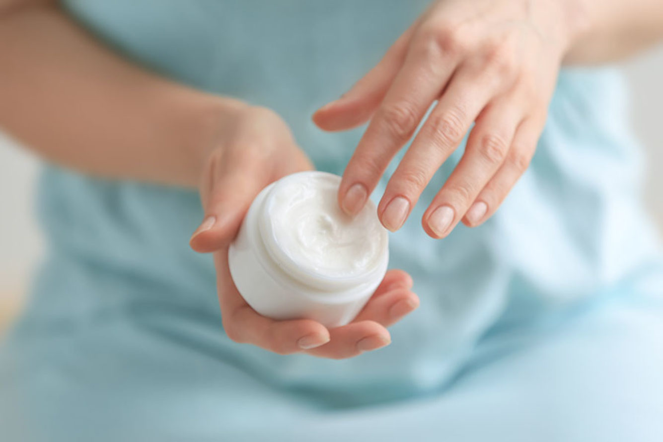 A person holding a skin cream