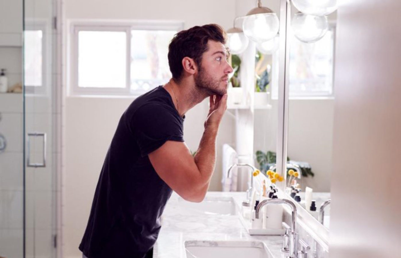 Man Washing face with Tri Wash in Bathroom